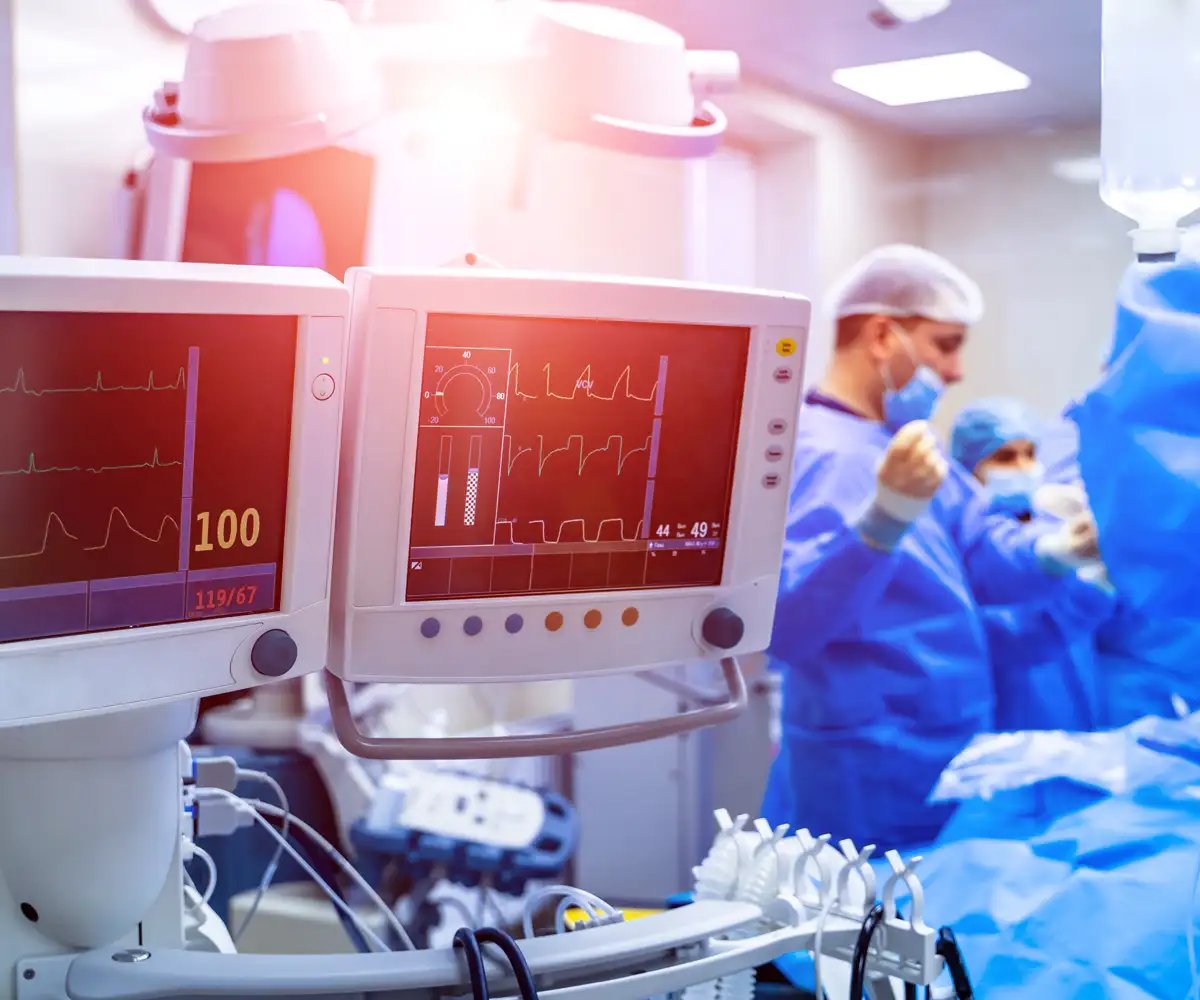 EKG machine with surgeons in the background